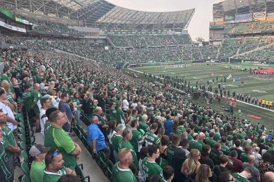 Thousands of fans stand during a moment of silence at Mosaic Stadium as the Saskatchewan Roughriders remember Bhishma Rajyaguru and Jayden Dalke before kickoff in Regina.