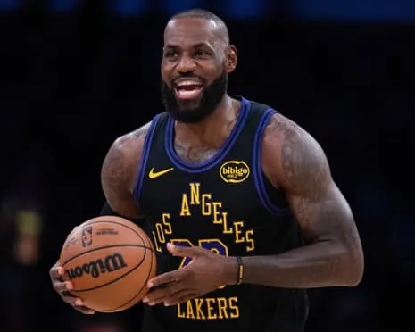 LeBron James holds a basketball and smiles during a Los Angeles Lakers game.